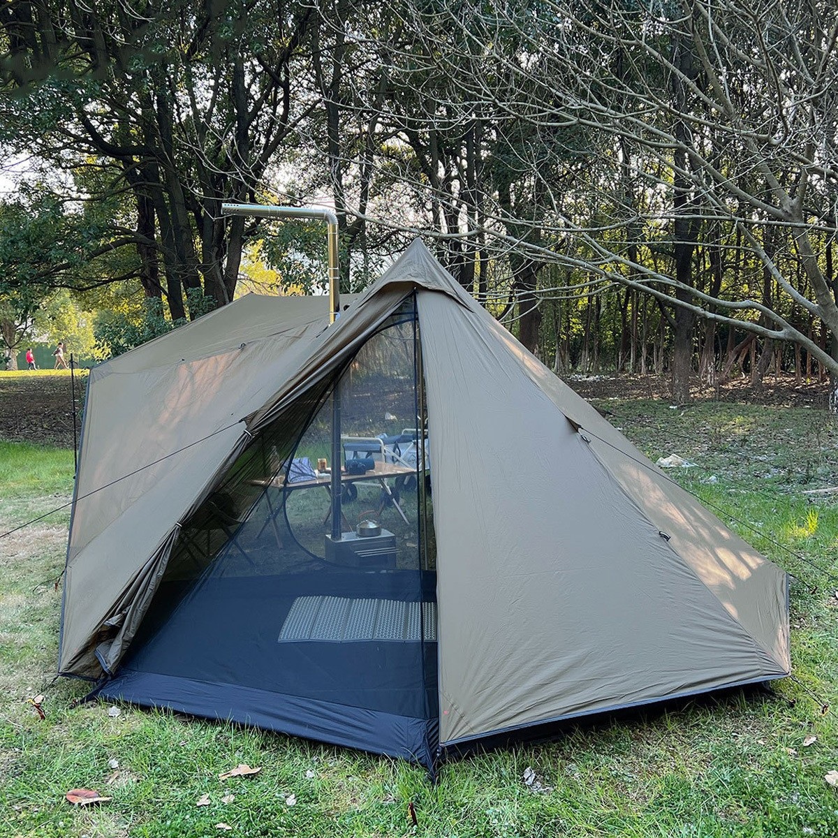 Taupe pyramid fly shelter with a peaked roof, mesh entry area and a flue passage, pitched in woodland.