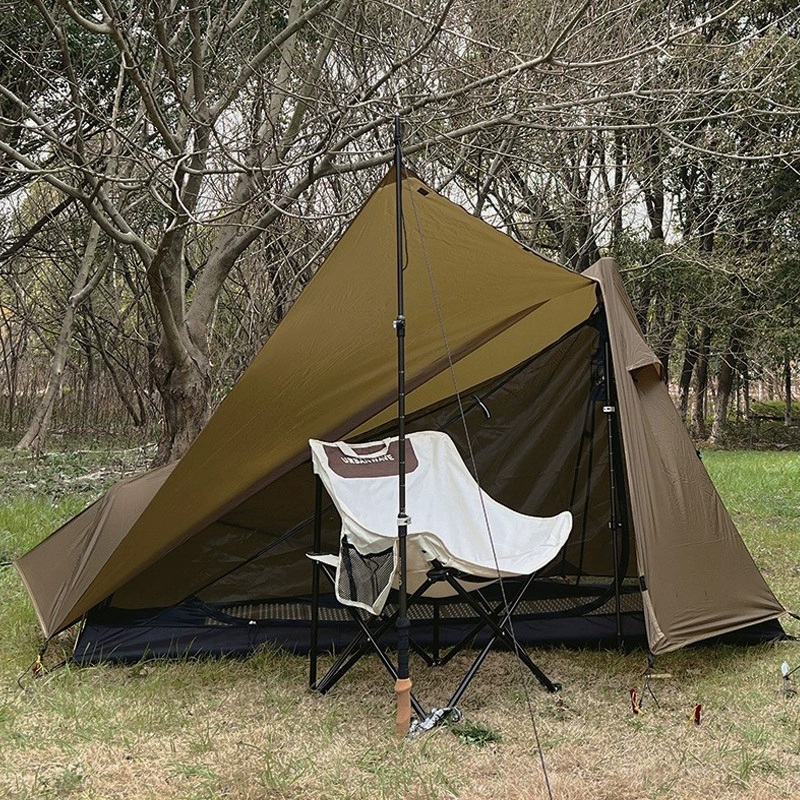 Brown triangular trekking tent with an open fly, mesh entry and dark floor, pitched with trekking poles beside a chair.