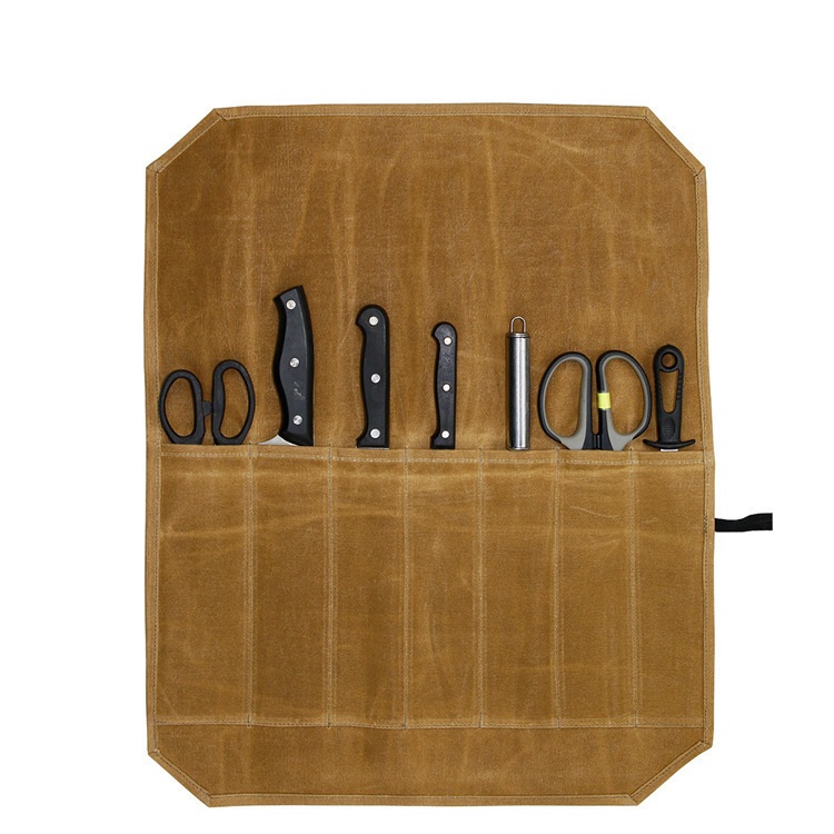 Open khaki canvas tool roll with stitched pockets and cooking tools shown for illustration.