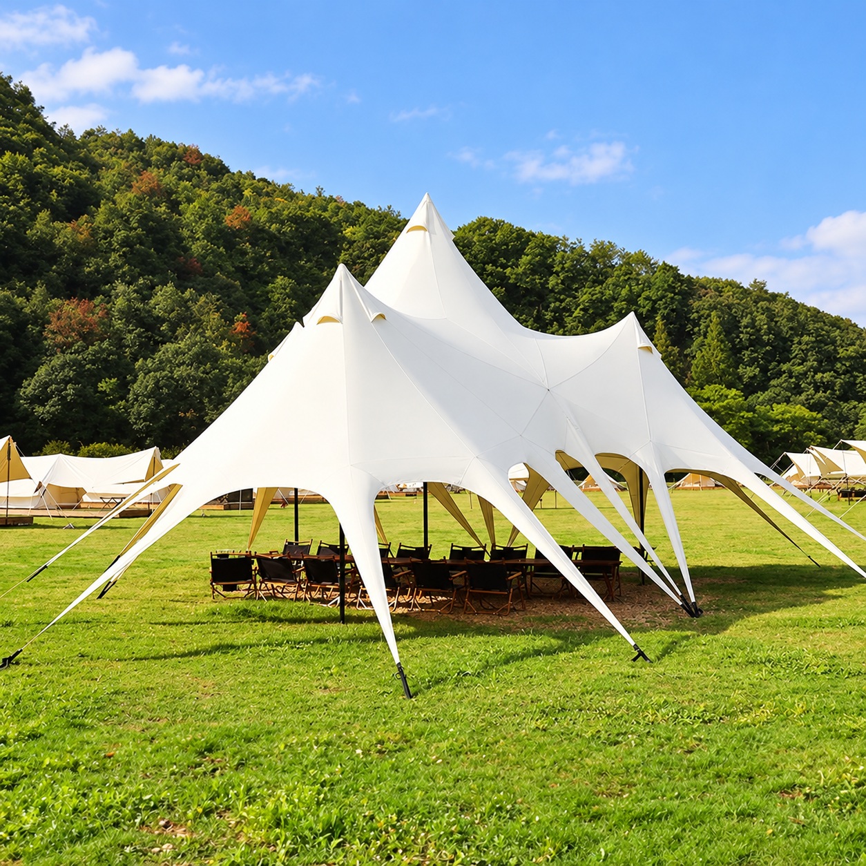 White multi-peak stretch canopy with pointed fabric legs surrounding an outdoor seating area