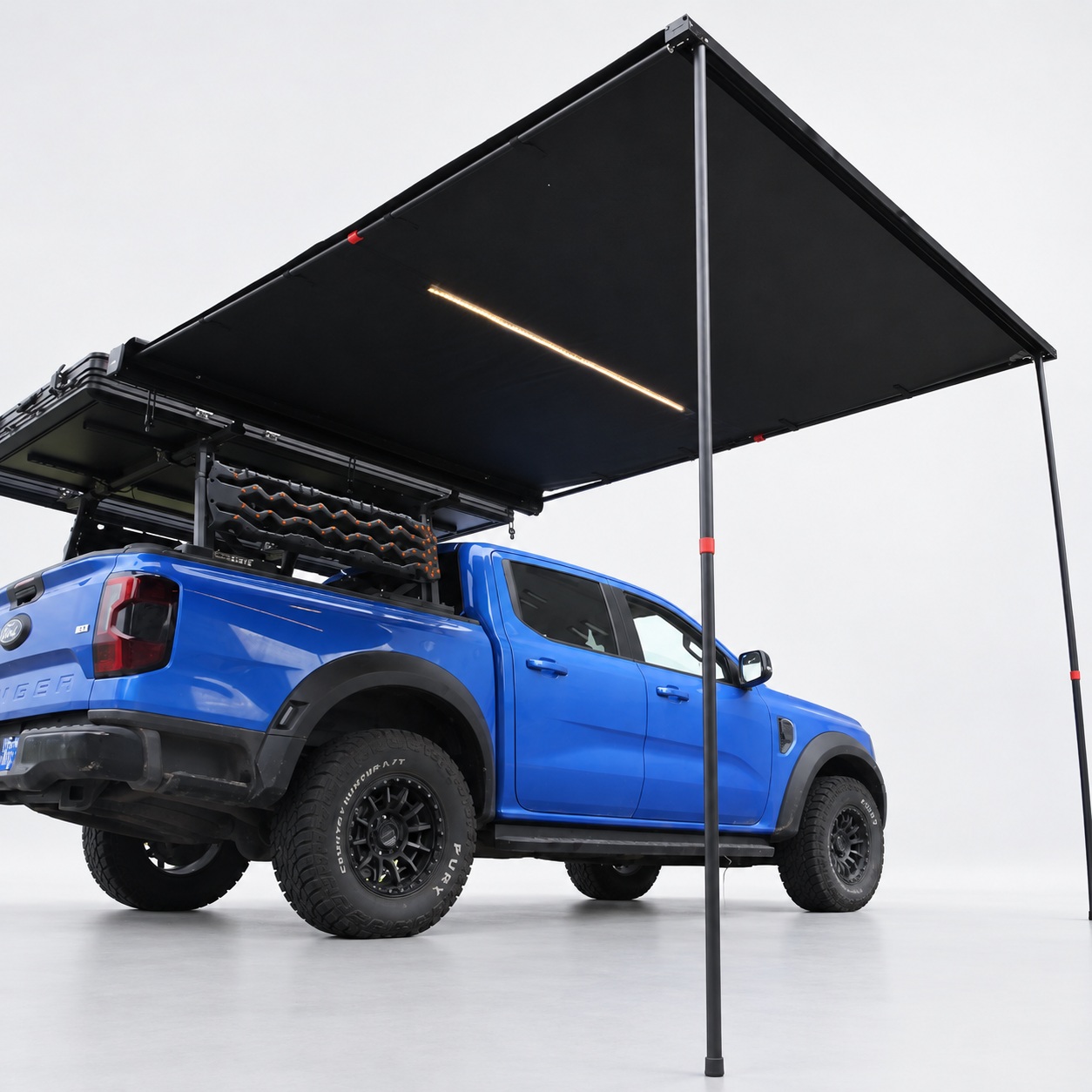 Black vehicle-side canopy mounted above a blue pickup
