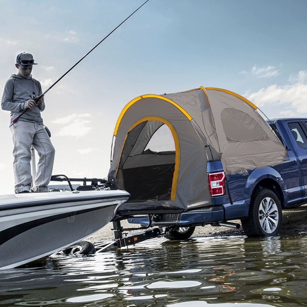 Gray pickup-bed tent with yellow pole sleeves and an arched doorway, installed on a blue pickup beside a boat.
