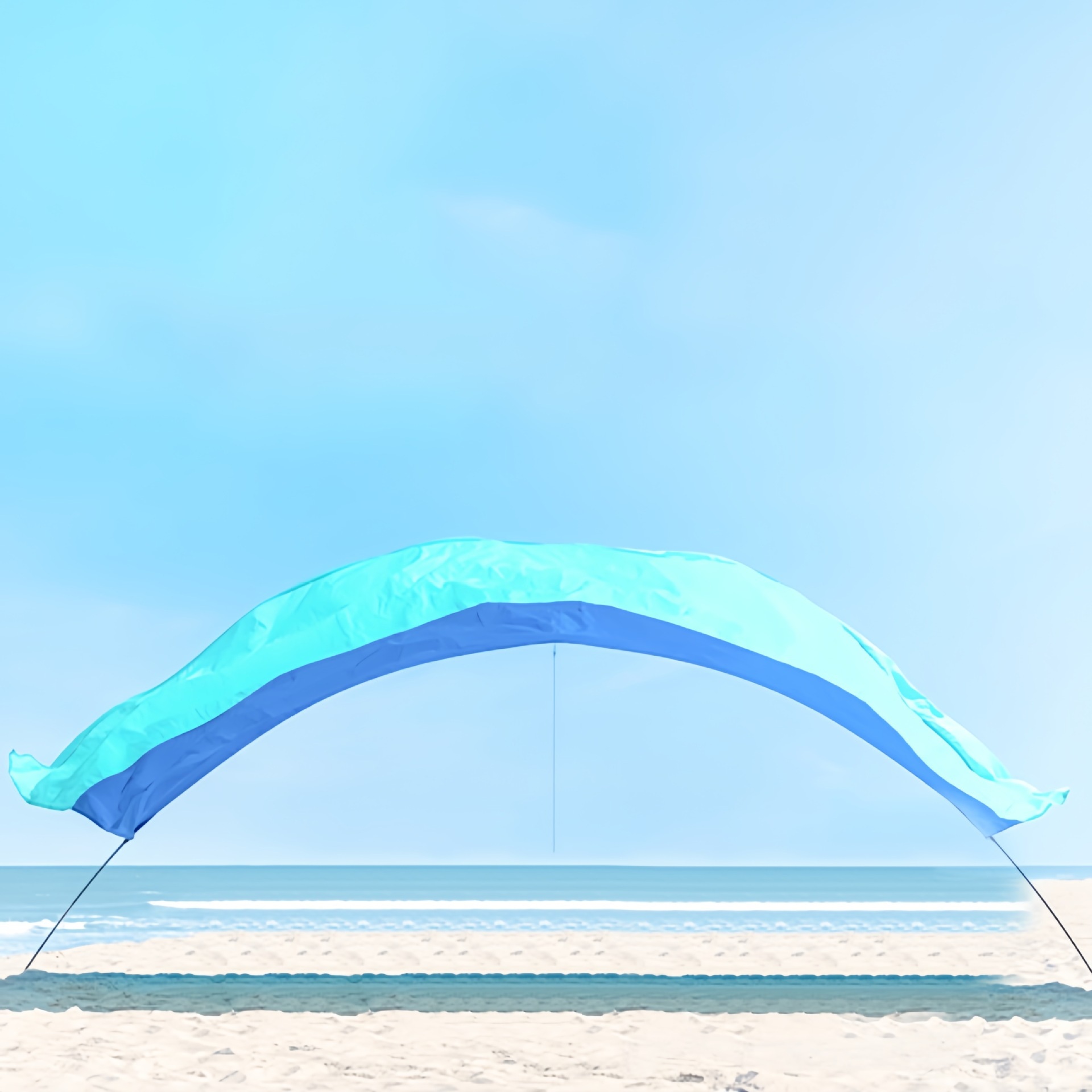 Blue and turquoise beach canopy stretched over a curved support above the sand.