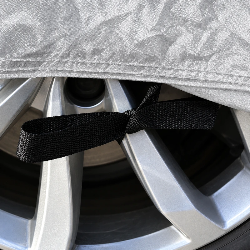 Black vehicle-cover strap shown beside an unbranded wheel